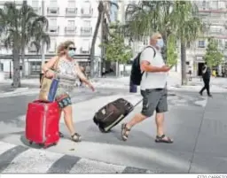  ?? FITO CARRETO ?? Turistas con sus mascarilla­s por la plaza de San Juan de Dios de Cádiz.