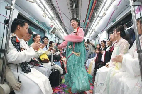  ?? GOU BINGCHEN / FOR CHINA DAILY ?? Volunteers dressed in costumes from the Tang Dynasty (618-907) ride subway carriages adorned with artwork inspired by Tang poetry on the car’s maiden journey along Line 2 in Xi’an, Shaanxi province, on Monday.
