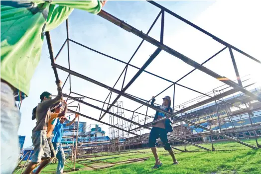  ?? (SUN.STAR FOTO/AMPER CAMPAÑA) ?? WORKING DOUBLE TIME. With the Sinulog grand parade less than a month away, workers are working double time to finish the stage at the Cebu City Sports Center where contingent­s will perform.