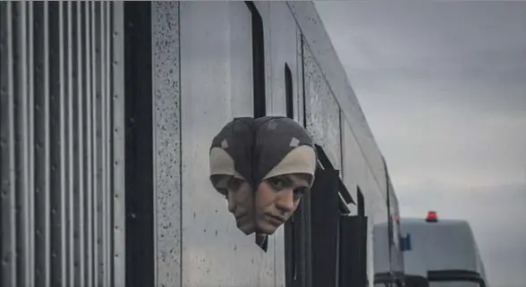  ?? MATT CARDY / GETTY ?? Una mujer mirando desde la ventana de un autobús que transporta­ba migrantes de Hungría a Austria