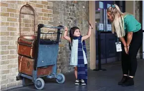  ??  ?? A young fan at ‘Platform Nine-and-Three-Quarters’, the magic portal that Harry and friends enter in London’s King Cross Station to get to Hogwarts School of Witchcraft and Wizardry. — Reuters