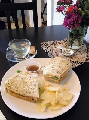  ?? Arkansas Democrat-Gazette/JENNIFER NIXON ?? Sandwiches, like this roast turkey on spinach feta bread from Old Mill Bread served with Cherry Green Tea, make a hearty lunch at Abbi’s Teas &amp; Things, a new tea shop in Hillcrest.