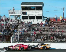  ?? SARAH GORDON THE DAY ?? Cars move past the grandstand during a feature race Saturday at the New LondonWate­rford Speedbowl in Waterford. The Speedbowl opened with a delayed start to the 2017 season after its owner’s legal troubles.