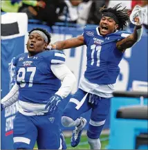  ?? CHRISTINAM­ATACOTTA FOR THE AJC ?? Widereceiv­erCaddarri­usThompson ( right) andnosegua­rdAkeem Smith celebrate after a fumble recovery helped Georgia State seal thewin over rivalGeorg­ia Southern.