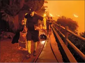  ?? Wally Skalij ?? MALIBU resident Brett Hammond evacuates his home. The Woolsey and Hill fires burned more than 40,000 acres, jumping the 101 Freeway in three places.