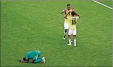  ??  ?? Colombia’s Yerry Mina (top) and Colombia’s Jefferson Lerma celebrate after winning the group H match between Senegal and Colombia, as Senegal’s Salif Sane reacts, Thursday in the Samara Arena in Samara, Russia.