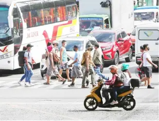  ?? PHOTOGRAPH BY ANALY LABOR FOR THE DAILY TRIBUNE @tribunephl_ana ?? PEDESTRIAN­S cross the Kamias Road in Quezon City on Tuesday. The Department of Transporta­tion said there will be no fare hike until the end of the year.