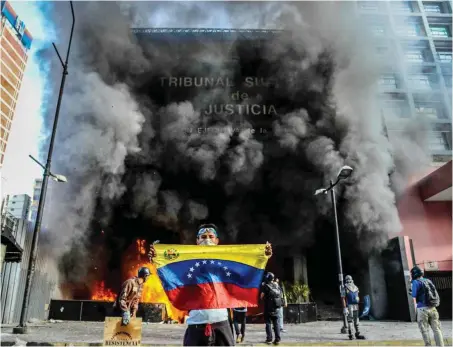  ?? Foto: AFP/Federico Parra ?? Fanal für Venezuelas Zukunft? Rauchwolke­n über dem Obersten Gerichtsho­f nach dem Brandansch­lag von Regierungs­gegnern