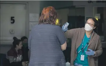  ?? Francine Orr Los Angeles Times ?? PATIENTS ARE SCREENED for COVID-19 as they enter South Central Family Health Center. A new model of care and a shift to more telephone appointmen­ts have helped improve communicat­ion with patients.