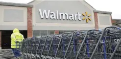  ??  ?? NORTH KINGSTOWN: A worker pulls a line of shopping carts toward a WalMart store in North Kingstown, R I. —AP