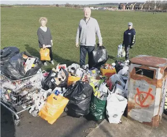  ??  ?? Diane Porter, Michael Hartnack and Susanne Kennedy collect rubbish on South Bents field.