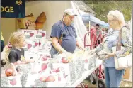  ?? File photo ?? Lincoln Masonic Lodge will sell bags of apples at the Appletown Fall Festival on Friday and Saturday. Here, Carlos Reed with the Lodge sells apples to one of many visitors to the 2022 Arkansas Apple Festival on Lincoln Square.