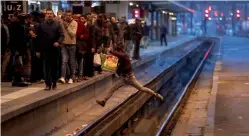  ?? — AP ?? A passenger crosses railroad tracks at rush hour at Gare de Lyon train station, in Paris, France, as union stage a mass strike on Tuesday.
