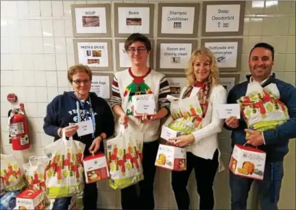  ?? DAN SOKIL — DIGITAL FIRST MEDIA ?? Penndale Middle School staff and student Connor Niszczak hold thank-you notes and food items donated to a school pantry for distributi­on to local families. From left to right are guidance attendance secretary Kim Moore, Niszczak, history teacher Deanna Bratina and assistant principal Jason Bashaw.