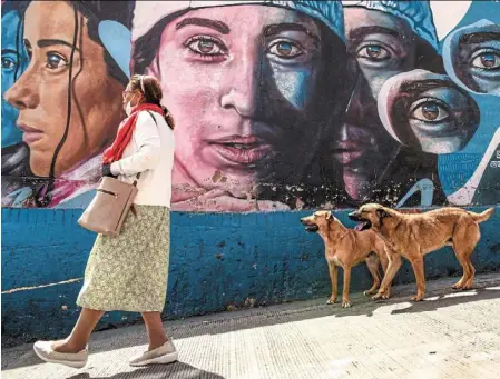  ?? AFP ?? as the tour winds through the vibrant streets of Bogota’s Ciudad Bolivar neighbourh­ood, a woman strolls past colourful graffiti adorning the walls, each mural telling its own story of the community’s history and culture. Photos: