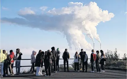  ?? REUTERS ?? People watch smoke and steam billow from Belchatow Power Station, Europe’s largest coal-fired power plant powered by lignite, in Zlobnica, Poland on Oct 20, 2022.