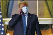  ?? ALEX BRANDON — THE ASSOCIATED PRESS ?? President Donald Trump removes his mask as he stands on the balcony outside of the Blue Room as returns to the White House in Washington after leaving Walter Reed National Military Medical Center in Bethesda, Md.