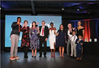  ?? Jacob Hernandez/UTSA Athletics ?? The members of UTSA’s inaugural Hall of Fame class pose on stage during the induction ceremony Friday at Pedrotti’s Ranch. From left to right, Devin Brown, McKenzie Adams’ mother Terri Adams, Lynn Hickey, McKenzie Adams’ father Van Adams, Tameka Roberts, UTSA athletic director Lisa Campos, Larry Coker, and Marcus Davenport’s wife Alexa with sons Johann and King.