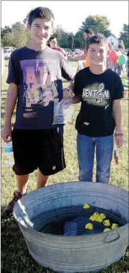  ?? RITA GREENE/MCDONALD COUNTY PRESS ?? Dylan Stephens, left, and Mason Stephens from Goodman conducting the Pick-a-Duck-Game at the Ozark Orchard Festival in Goodman Saturday.