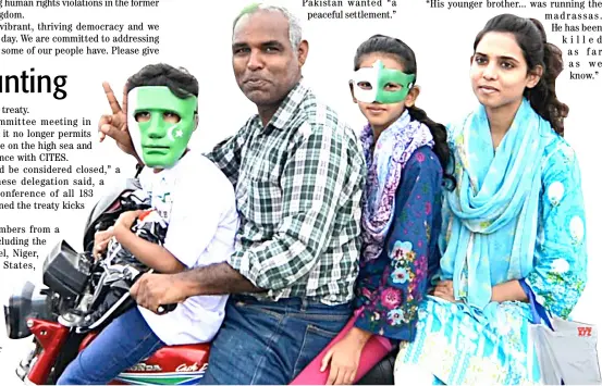  ??  ?? PAKISTANI people wearing masks painted with national flag color during the Independen­ce Day celebratio­ns in Islamabad, Pakistan.