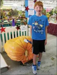  ??  ?? Ian Johnson, 11, of Vermont posing with a 380lb. pumpkin during the 2016Schagh­ticoke Fair.