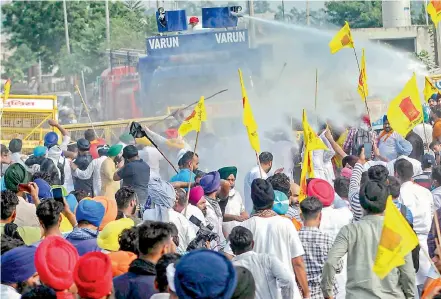  ?? —PTI ?? Police use water cannons to disperse supporters of Lok Insaaf Party (Punjab) during a protest over the passage of recent farm Bills and electricit­y amendment Bill, at Punjab-Haryana border in Ambala district on Wednesday. The Haryana police also on Wednesday used water cannons in Panipat and Ambala on agitators to stop them from proceeding to Delhi to protest against the farm reform Bills.