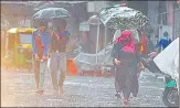  ?? SANCHIT KHANNA/HT PHOTO ?? People walk with umbrellas amid heavy showers near Jama Masjid n in New Delhi on Sunday.