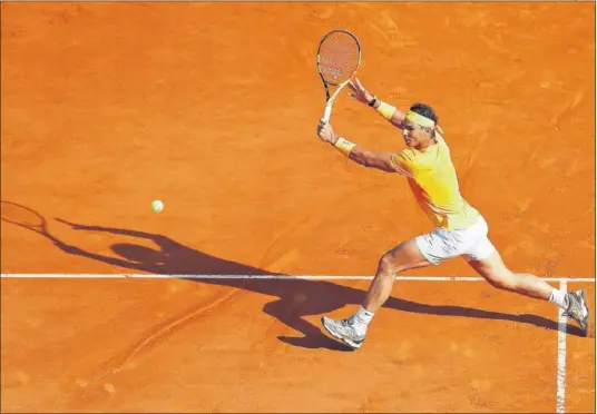  ??  ?? ESTILO Y POTENCIA. Rafa Nadal se dispone a ejecutar un revés cortado en la pista Raniero III de Montecarlo en su duelo contra Thiem.