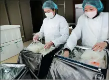  ?? XU CONGJUN / FOR CHINA DAILY ?? Two employees of a restaurant in Nantong, Jiangsu province, pack takeaway meals.