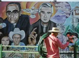 ?? Photos by Salvador Melendez / Associated Press ?? A mural features St. Oscar Romero and the Rev. Rutilio Grande in the Plaza de Los Martires, or Martyrs Square, in El Paisnal, El Salvador.