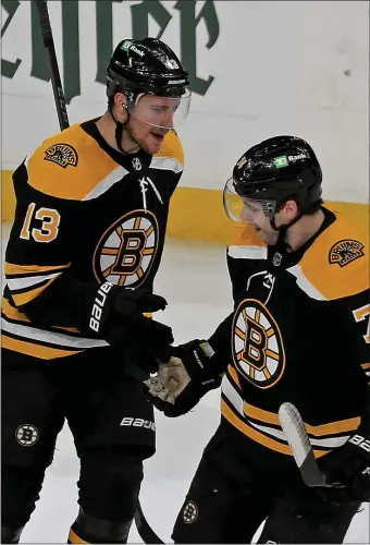  ?? STUART CAHILL / HERALD STAFF ?? BACK TOGETHER: Charlie Coyle and Jake DeBrusk celebrate their short-handed goal in Game 3 of the Bruins first-round playoff series with the Carolina Hurricanes at TD Garden on Saturday.