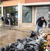  ?? ANTHONY VAZQUEZ/SUN-TIMES FILE ?? Johnny Leland is shown in June, dumping some shards of glass onto a trash pile from the aftermath of protests and looting on the South Side. Some Chicago aldermen want to bring in the Illinois National Guard to help with security downtown and in the neighborho­ods.