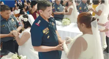  ?? SUNSTAR FOTO / ALAN TANGCAWAN ?? ‘I DO.’ Mandaue City Police Office Chief Julian Entoma and his wife, Socorro, say their vows during a mass wedding organized by the Police Regional Office 7.