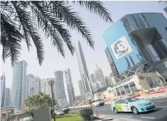  ?? AP ?? A taxi passes by a building with the image of the Emir of Qatar, Sheikh Tamim bin Hamad Al Thani, in Doha, Qatar.