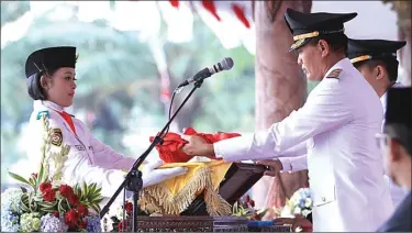  ?? BAGAS BIMANTARA/JAWA POS RADAR MADIUN ?? SAKRAL: Wakil Wali Kota Madiun Sugeng Rismiyanto menerima bendera Merah Putih dari anggota paskibra dalam upacara penurunan bendera kemarin.