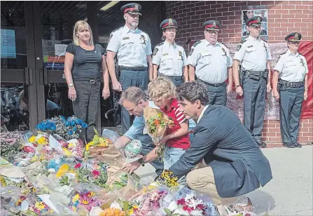  ?? ANDREW VAUGHAN THE CANADIAN PRESS ?? Prime Minister Justin Trudeau, accompanie­d by his four-year-old son, Hadrien, and Fredericto­n MP Matt DeCourcey place flowers at a memorial.