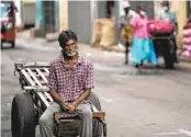  ?? ERANGA JAYAWARDEN­A AP ?? A daily wage laborer waits for work at a wholesale market in Colombo, Sri Lanka, on Sunday.