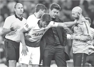  ?? - AFP photo ?? Tottenham Hotspur’s Argentinia­n head coach Mauricio Pochettino (2R) helps Tottenham Hotspur’s Belgian defender Jan Vertonghen (C) as he leaves the pitch injured during the UEFA Champions League semi-final first leg football match between Tottenham Hotspur and Ajax at the Tottenham Hotspur Stadium in north London.