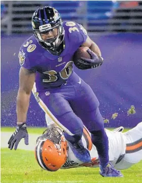  ?? KARL MERTON FERRON/BALTIMORE SUN ?? The Ravens’ Kenneth Dixon gains 16 yards against the Browns in Thursday night’s 28-7 victory. “I just got back into the flow of things, and it felt good to be back,” he said after the game.