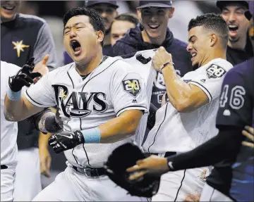  ?? Chris O’meara ?? The Associated Press Rays shortstop Willy Adames tries to pull off Ji-man Choi’s jersey after the designated hitter belted a two-run walk-off homer in the ninth inning of Tampa Bay’s 6-5 win over the Indians on Monday at Tropicana Field.