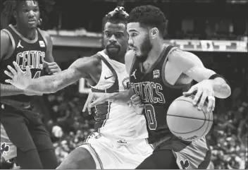  ?? MATT STRASEN/AP ?? BOSTON CELTICS FORWARD JAYSON TATUM (0) drives on Dallas Mavericks forward Reggie Bullock (25) during the first half of a game in Dallas on Saturday.