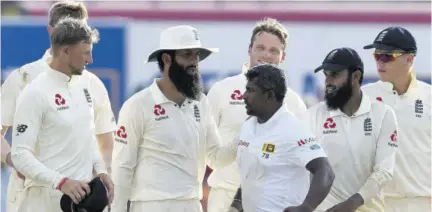  ?? (Photo: AFP) ?? Sri Lanka’s Rangana Herath (third right) walks off the field with England cricket team members after England won the opening Test match against Sri Lanka at the Galle Internatio­na Stadium in Galle yesterday.