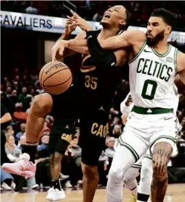  ?? JASON MILLER/GETTY IMAGES ?? Isaac Okoro of the Cavaliers is fouled on his way to the basket by the Celtics’ Jayson Tatum in the second half.
