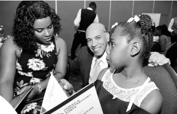  ?? PHOTOS BY RUDOLPH BROWN/PHOTOGRAPH­ER ?? Police Commission­er Major General Antony Anderson cheers up Jodi-Ann Miller and her daughter, Laviana Thomas, at yesterday’s Jamaica Constabula­ry Force luncheon for children of fallen officers.