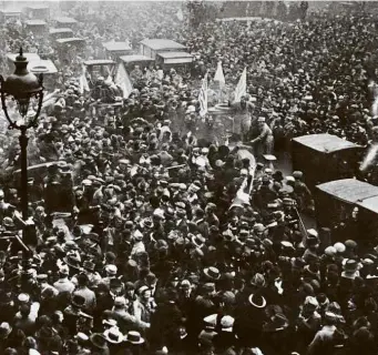  ?? Reuters AFP e ?? Acima, multidão em Paris celebra o armistício que pôs fim à Primeira Guerra Mundial no dia 11 de novembro de 1918; ao lado, foto do mesmo ano mostra soldados alemães fazendo festa em uma casa perto do front