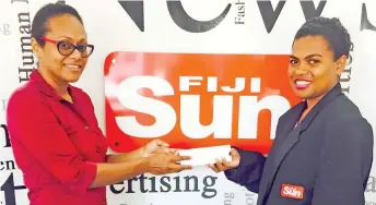  ??  ?? Joan Geralyne McGoon (left), receives a Parker pen from Fiji Sun reporter Litia Tikomailep­anoni at our Nadi office. Photo: Vinita Singh