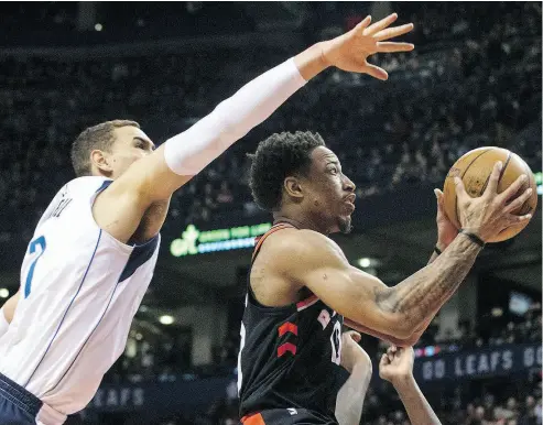  ?? CHRIS YOUNG / THE CANADIAN PRESS ?? DeMar DeRozan shoots past Dallas Mavericks centre Dwight Powell in Friday night’s game at the Air Canada Centre.