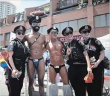  ?? MARK BLINCH THE CANADIAN PRESS ?? Participan­ts pose for a photos with police officers at the annual Pride Parade in Toronto on Sunday, July 3, 2016.