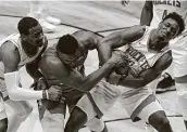  ?? Gerald Herbert / Associated Press ?? The Rockets’ Jae’Sean Tate tries to wrench the ball loose from the Pelicans’ Zion Williamson.