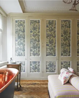  ??  ?? MASTER BATHROOM The deep bath was the starting point for the timeless decor. Wardrobes by Ben Pentreath; painted in Matchstick by Farrow & Ball; with chicken wire panelled doors lined in Les Quatre Parties du Monde Bleu Toile de Jouy